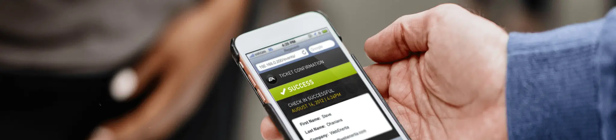 Close-up of a person holding a smartphone displaying a successful event ticket confirmation screen, with the focus on the mobile interface and blurred people in the background.