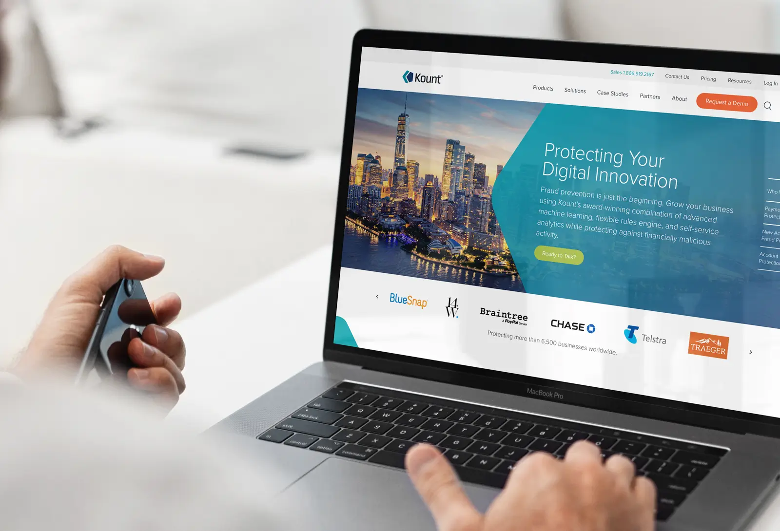 Person using a laptop displaying the Kount website