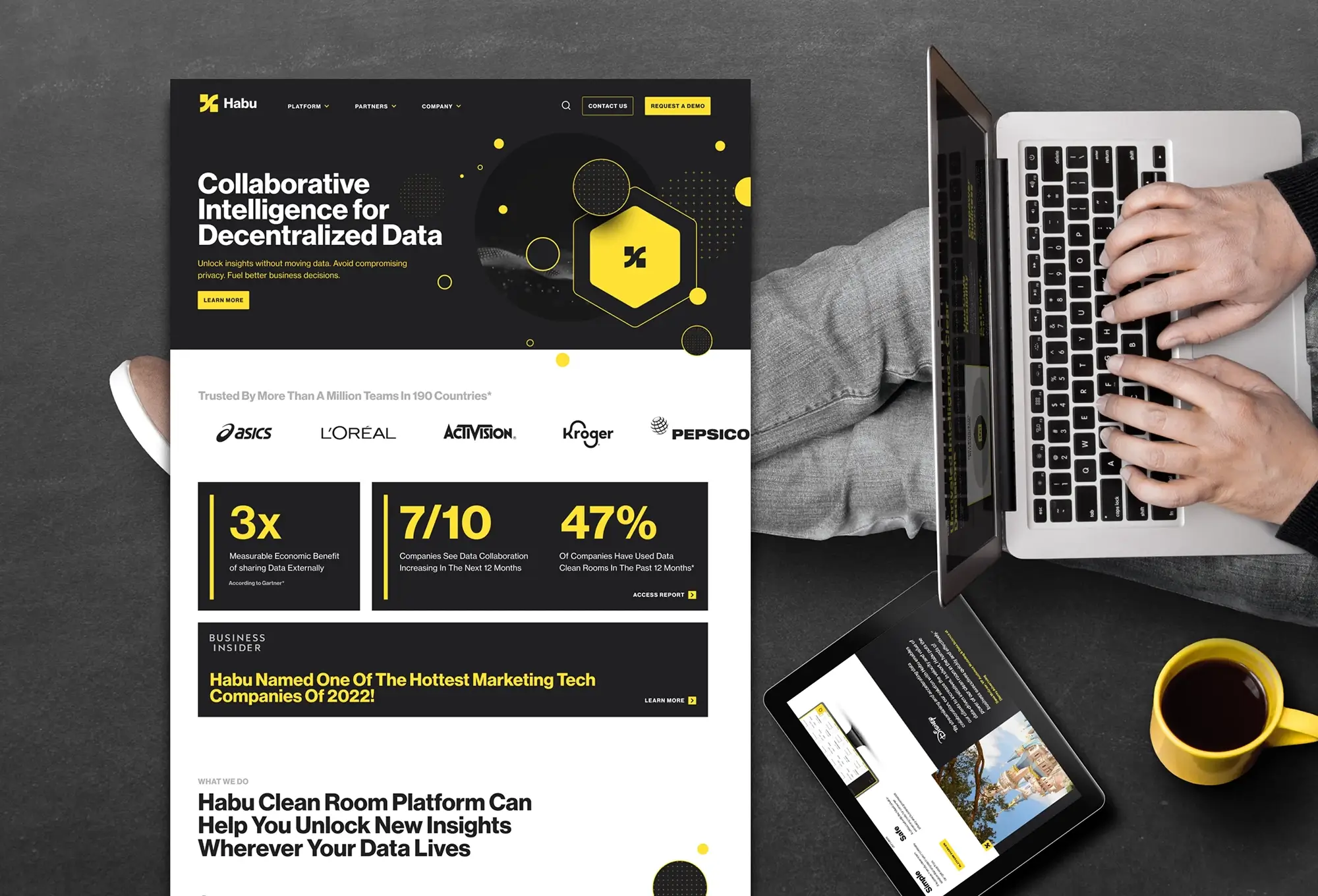 Laptop user next to a displayed Habu website design.